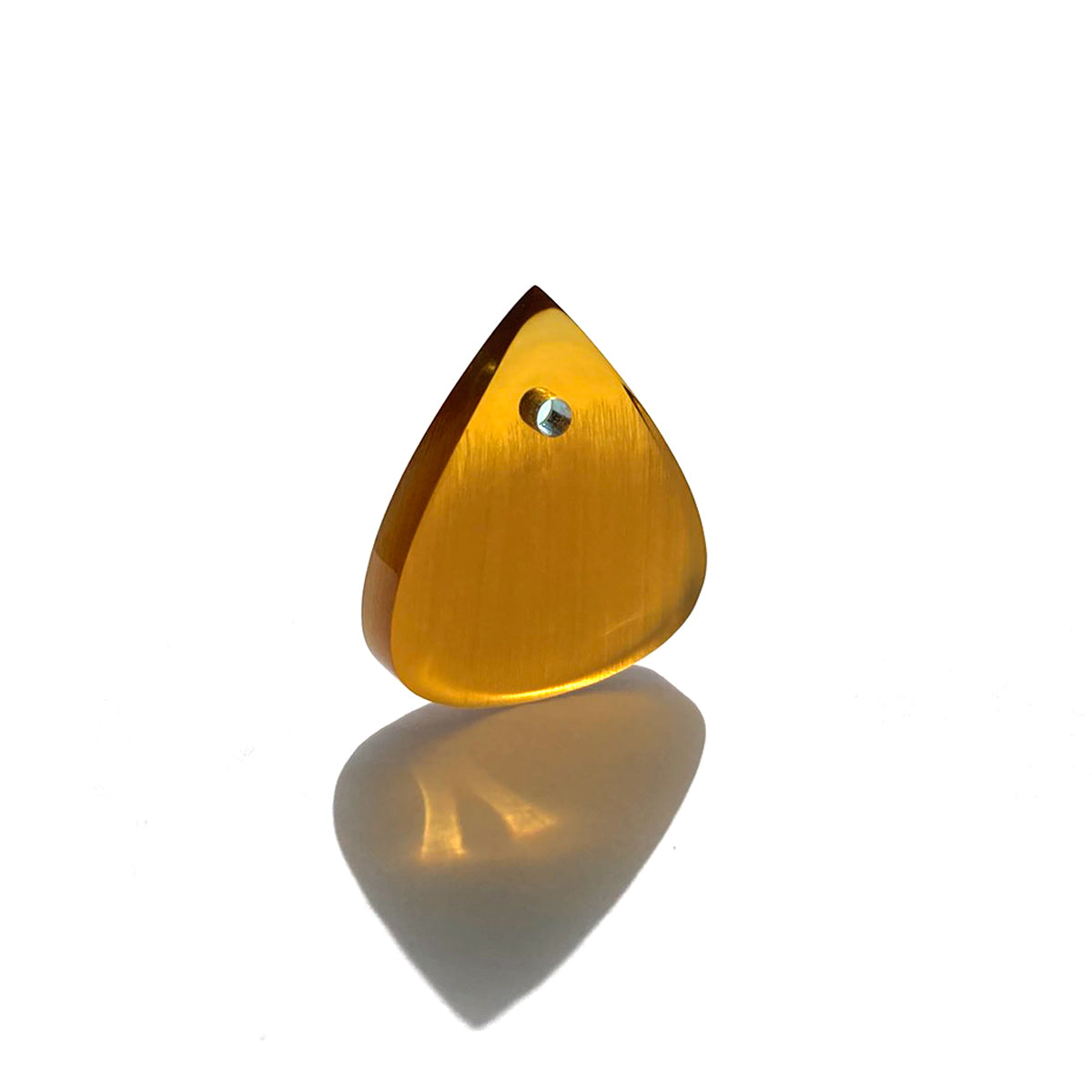 Amber color guitar pick in white background bathed in sunlight 