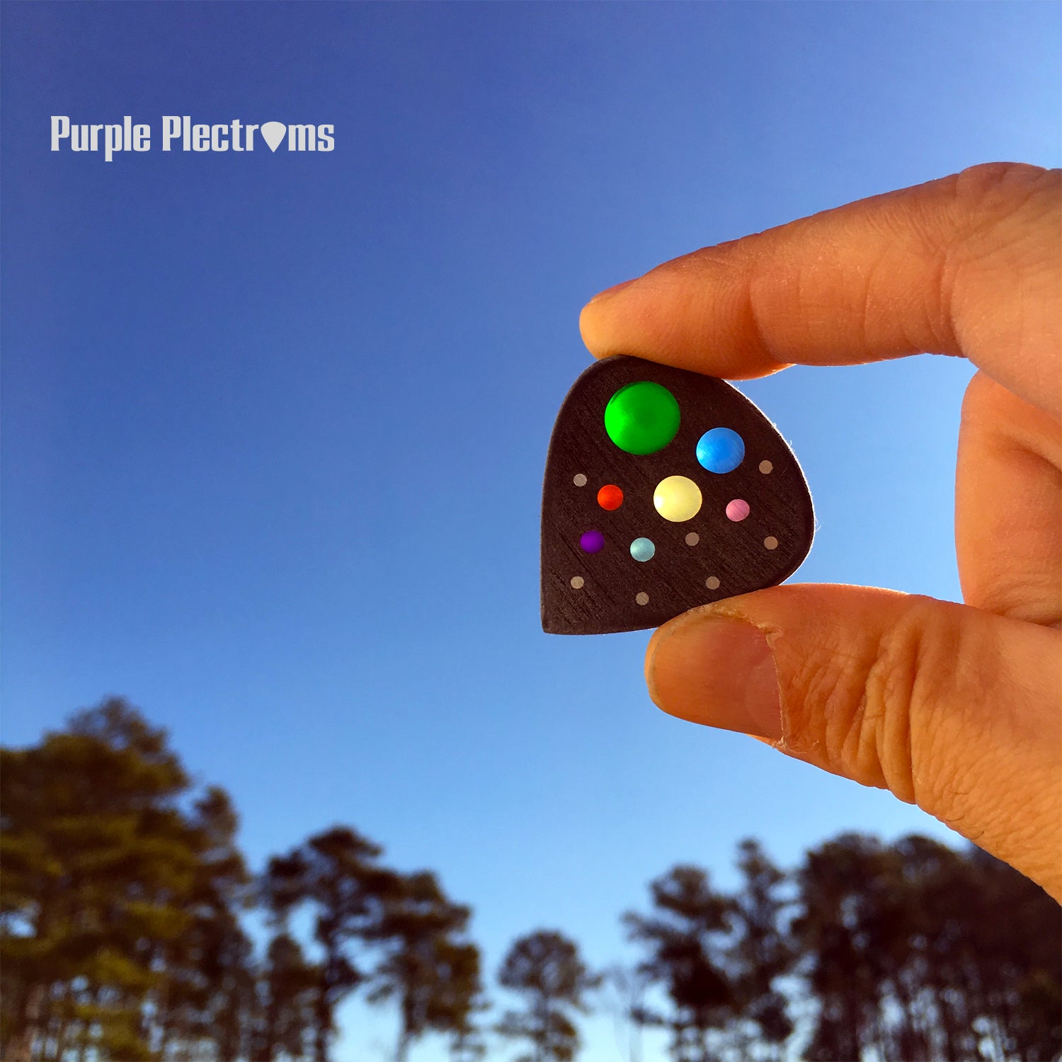 Guitar pick with many color optics designed to represent the solar system